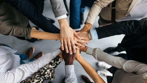 A group of co-workers stacking their hands together